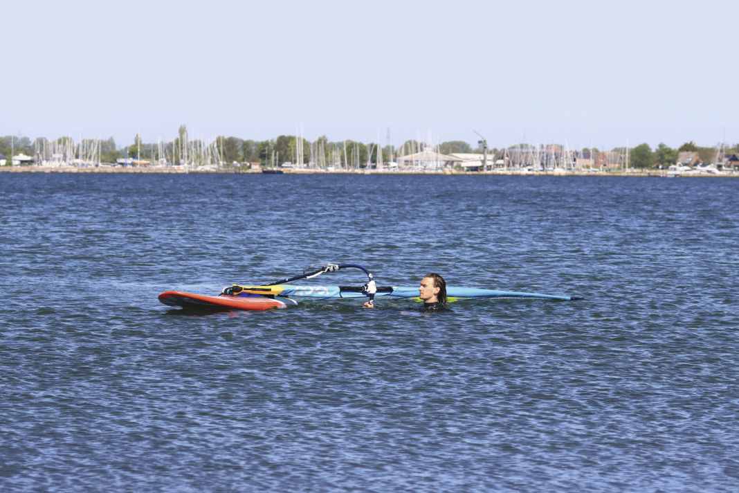 Positioning: First, position your board so that the bow is pointing diagonally to windward and the mast is more or less perpendicular to the wind direction. From this position, the wind can blow nicely into the sail straight away and, with a bit of help from you, lift it out of the water with ease.