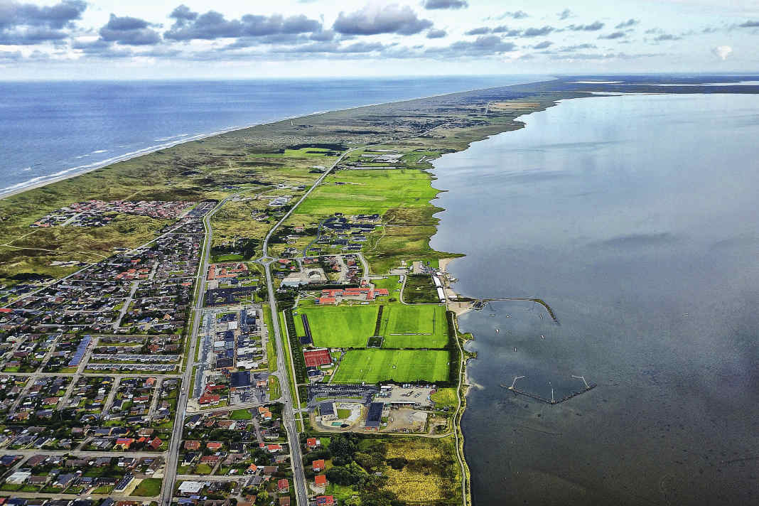 The narrow headland Holmsland Klit separates Ringkøbing Fjord from the North Sea. The picture shows the spot Hvide Sande Nord.