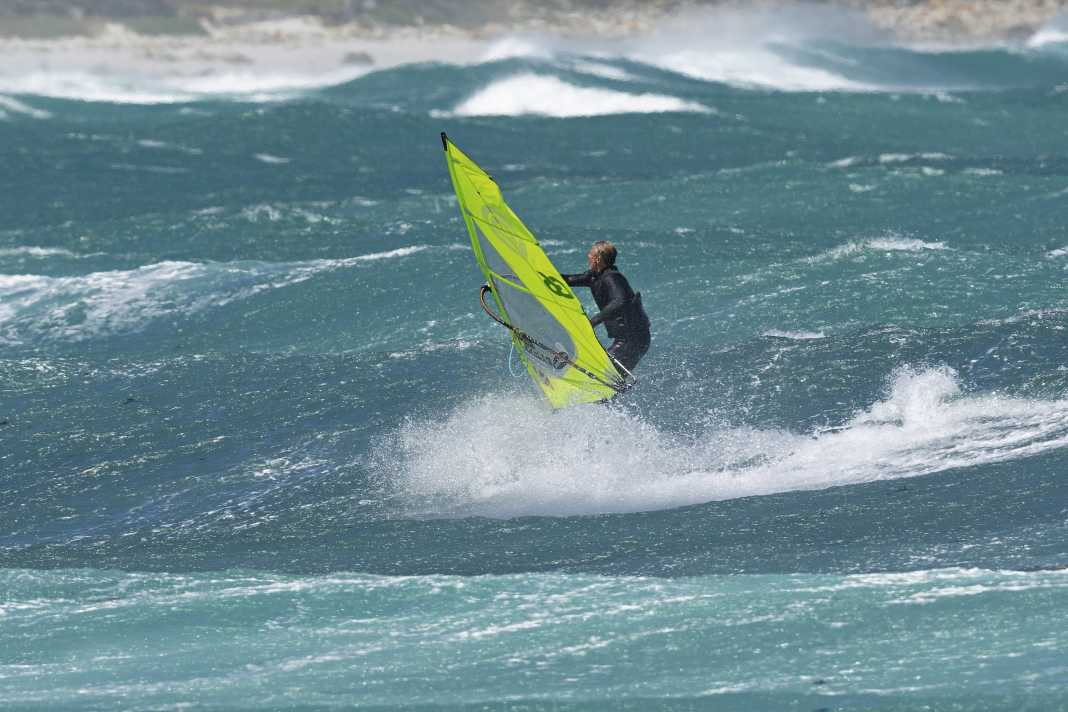 You should be well powered up and gather a lot of speed on the wave face. Carve over your heels up to the lip of the wave, but make sure you keep the board a little flatter so as not to stifle your speed. The approach is therefore usually done with a slightly wider radius.