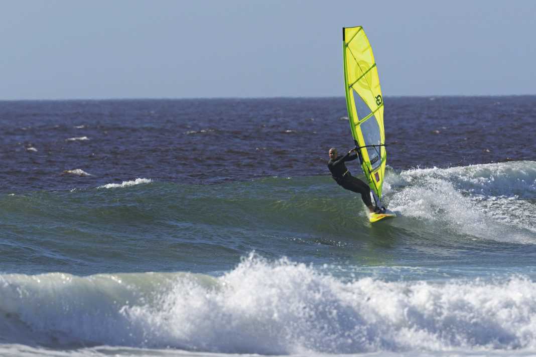 Gain as much speed as possible on the building wave and aim for the wave on the windward side.