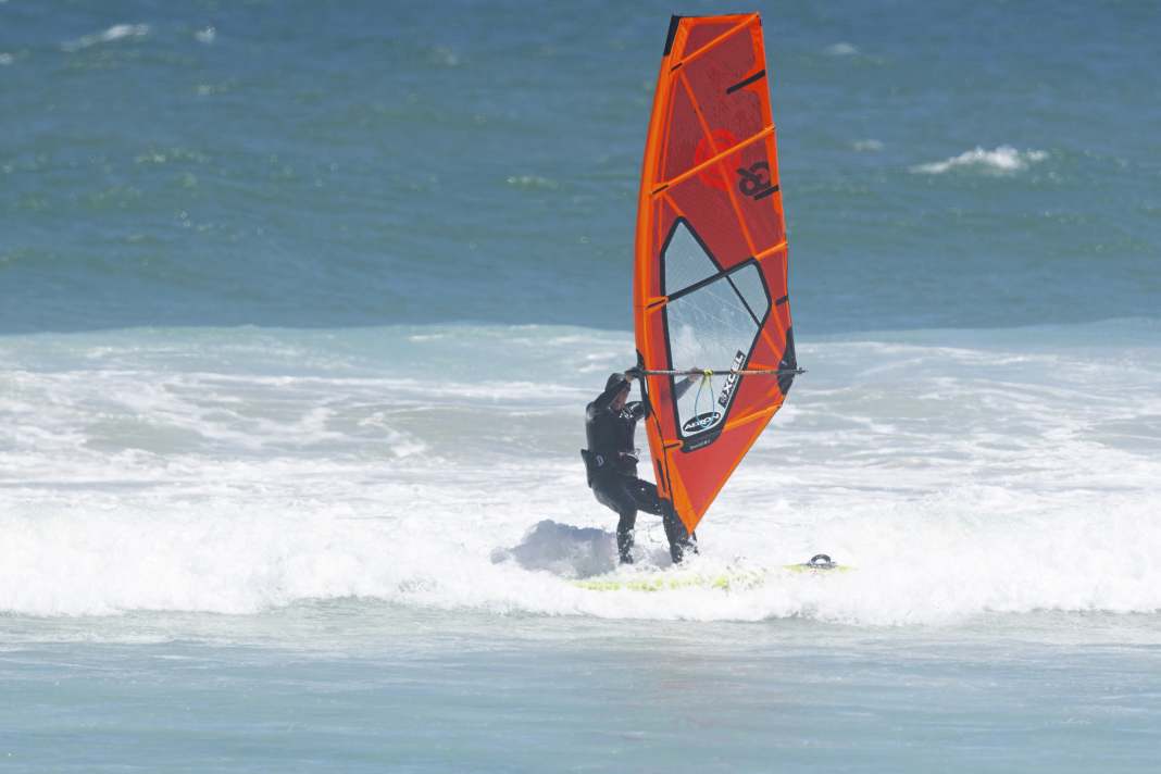 Glide towards the beach with a small foam wave on a light closehauled course - a knee-high wave is absolutely sufficient. Open the sail, unhook from the harness and simply let the wave push you. Take a big step forwards.