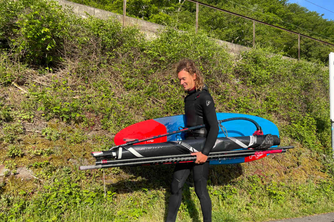 Segel, Mast und Gabelbaum klemmen unter dem einen Arm...