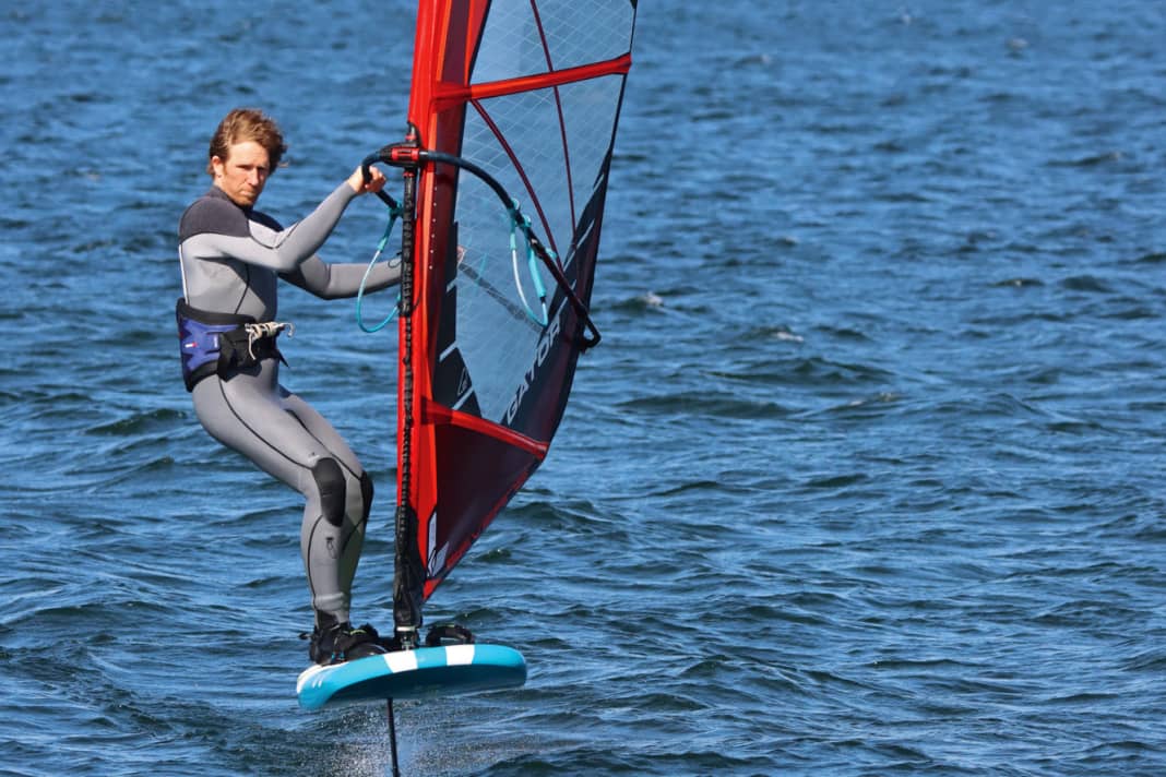 Check the free space downwind and unhook yourself from the harness. Take your back foot out of the loop and place it on the leeward edge of the board.