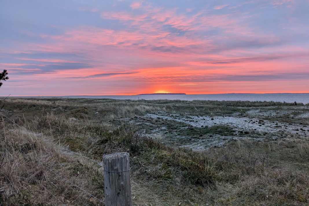 Von einigen Plätzen auf Flyvesandet kann man traumhafte Sonnenuntergänge über der kleinen Insel Æbelø ansehen