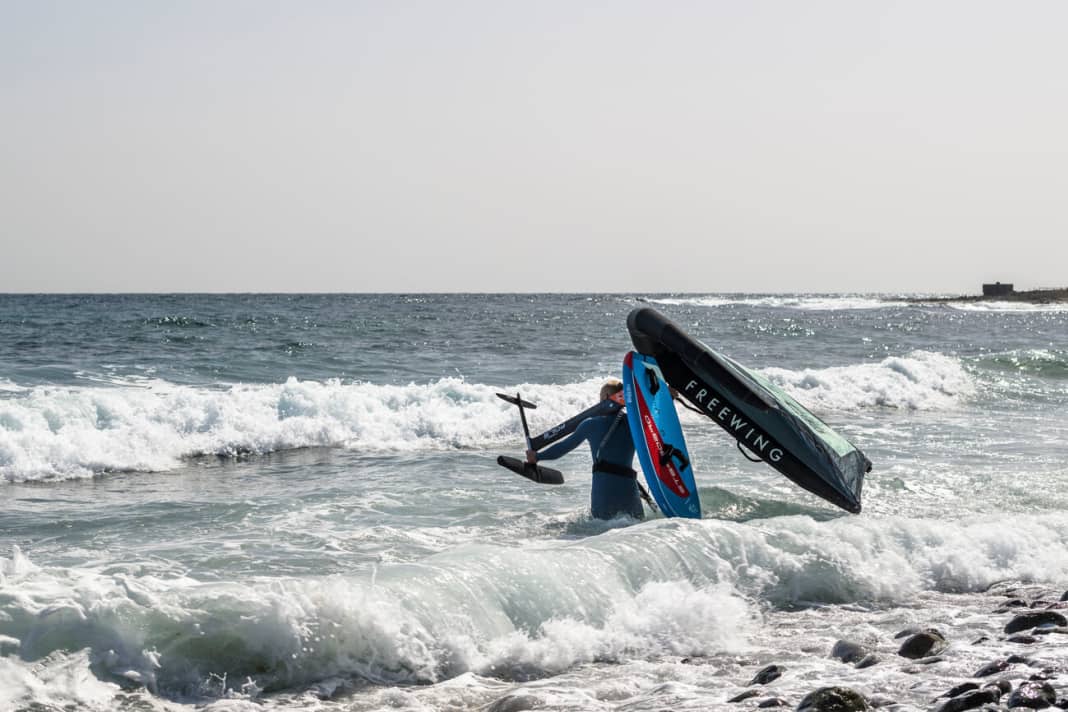Walk carefully into deep water with the board on your shoulder