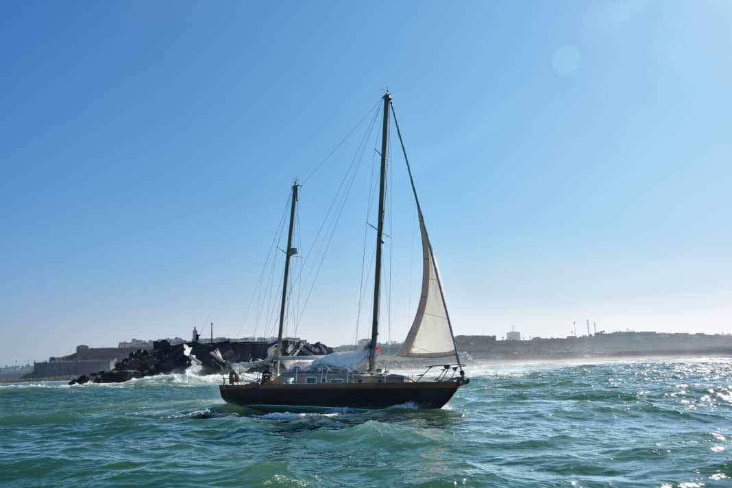 Uno yacht lascia il porto di Rabat. A poppa c'è un imponente frangiflutti in pietra dove l'Atlantico si infrange con fragore durante le tempeste.