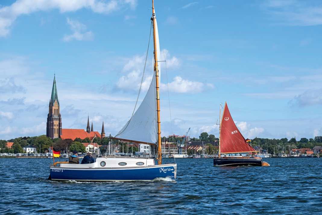 La flotte de bateaux craquants devant le décor de la ville de Schleswig avec la cathédrale et le port de plaisance