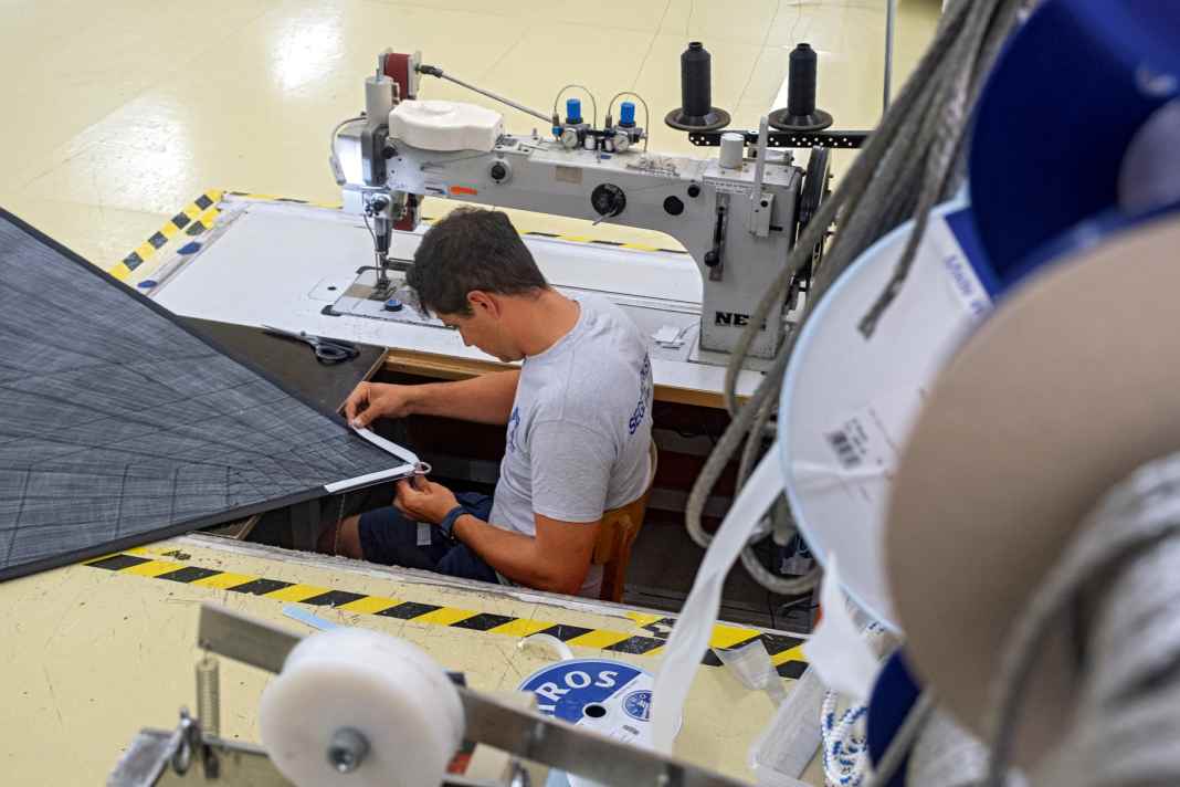 Le maître voilier Lennard Peilicke en train de terminer un génois noir