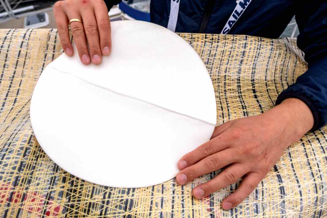 Spezielle Patches aus Nummerntuch mit zusätzlicher mittiger Verstärkung sind beim Segelmacher oder im Fachhandel zu bekommen. Beim Anbringen muss auch die Folie der mittigen Verstärkung abgezogen werden, sonst hält der Patch nicht lange