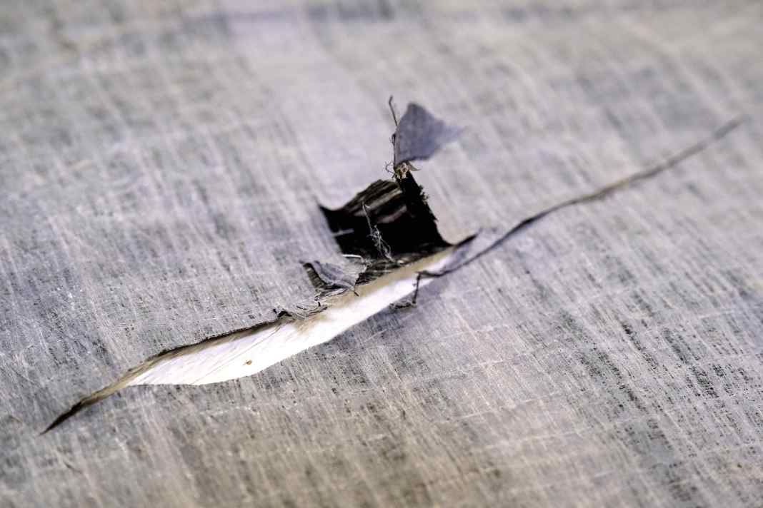 Regarder exactement quelle est la taille réelle de la fissure afin de déterminer la taille du patch. Ici aussi, la position de la zone endommagée est importante. Près des ralingues, de la tête, du cou et du point d'écoute, les charges sont plus importantes. Un patch plus grand aide à absorber et à répartir les forces.