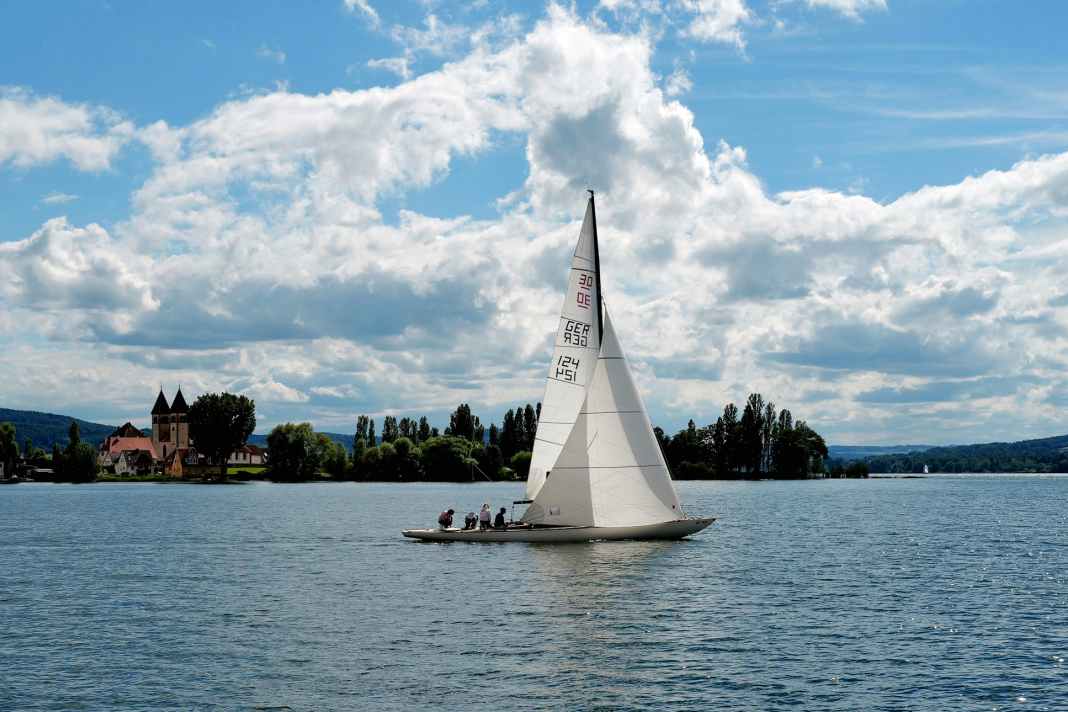 Un schärenkreuzer de 30 passe devant l'église St. Peter und Paul à Niederzell, à la pointe nord-ouest de Reichenau