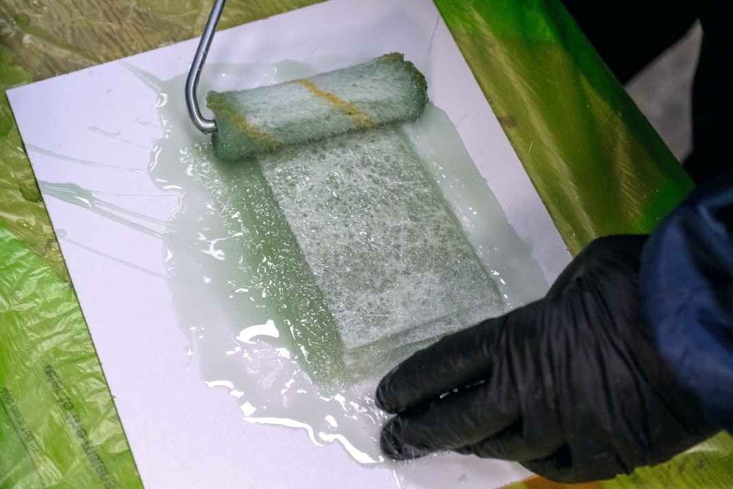 À l'intérieur, nous travaillons avec de la résine polyester et un matelas de fibres. Les bandes d'environ 15 centimètres de long sont pré-imprégnées par paquets de trois sur un film plastique, puis placées sous le pont.
