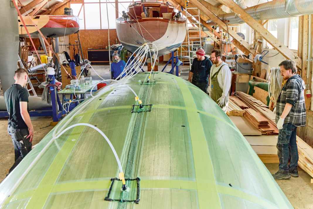 Tradition meets modernity. The second Woy under construction at the front, the first at the rear left and a fully planked yacht from the 70s in the background.