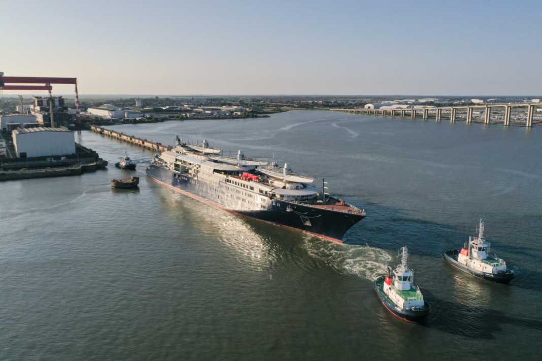 Tugboats pull the half-finished "Orient Express Corinthian" out of the dock.