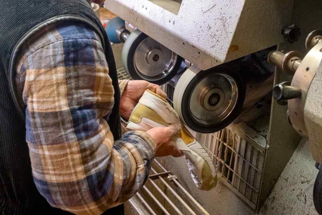 Riparazione professionale: prima di incollare la nuova suola, la vecchia deve essere levigata.