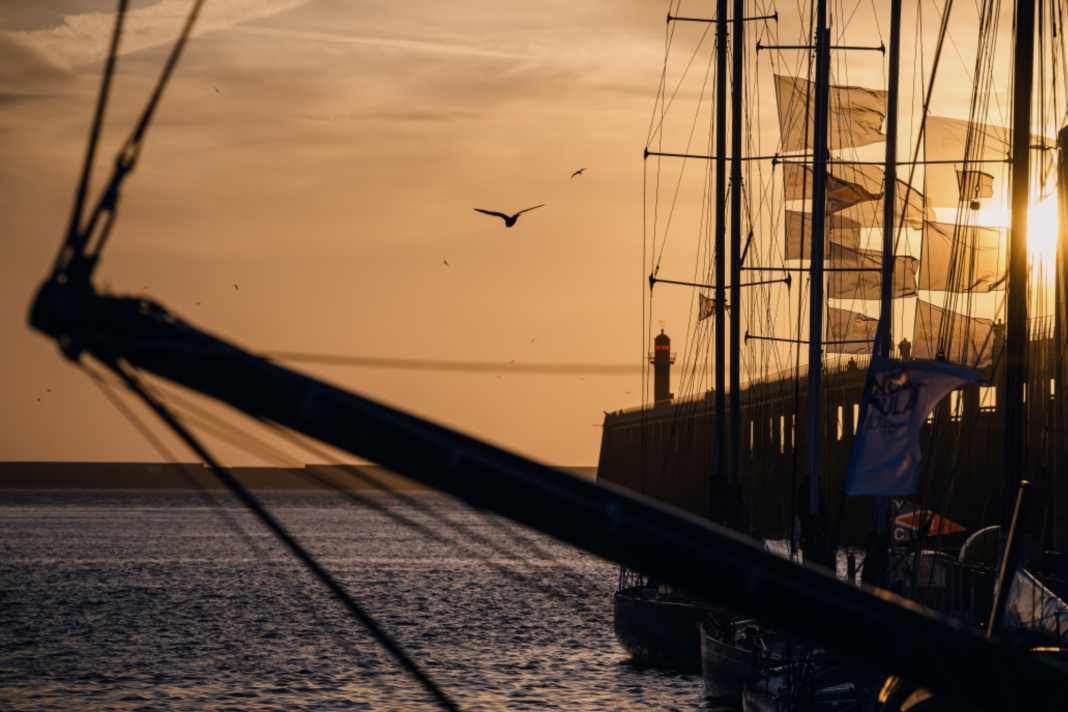 Fotograf Jean-Louis Carli setzt hier die Imoca-Szenerie in Boulogne vor dem Start des Course des Caps in goldenes Licht.