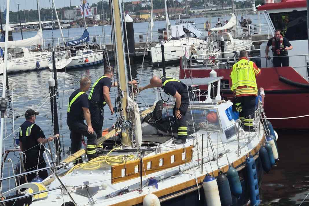 Untersuchung nach der schweren Detonation: Einsatzkräfte der Feuerwehr Kiel und der Wasserschutzpolizei inspizieren am Samstagmittag die betroffene Segelyacht im Sportboothafen Reventlou.