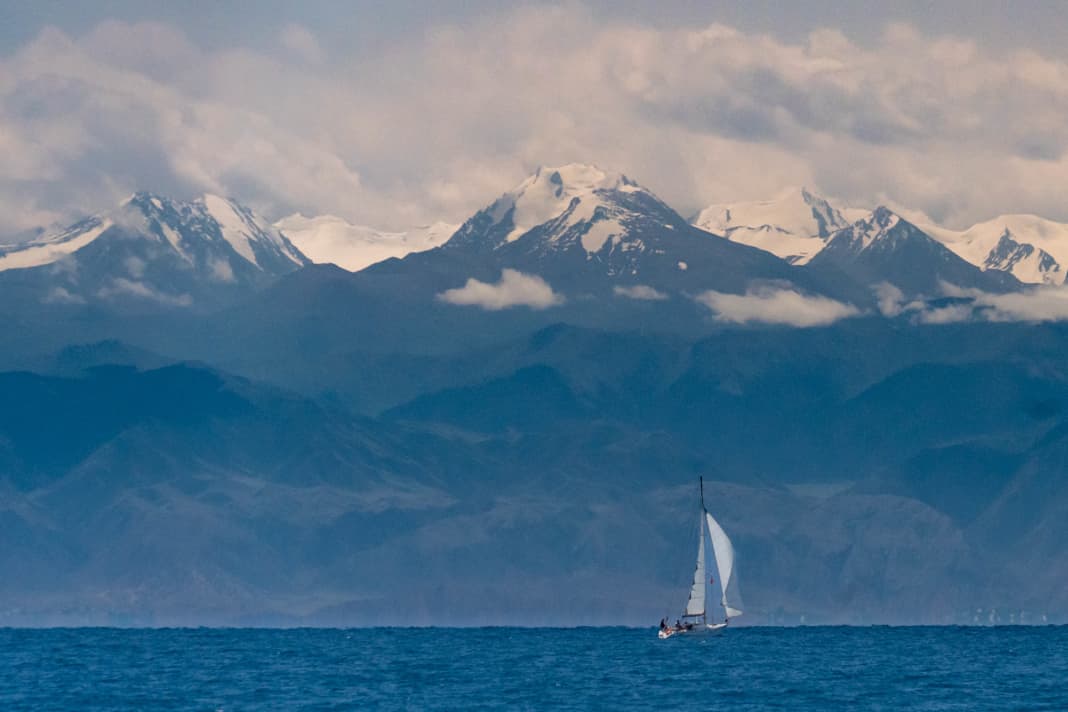 Platz 25: Eingekesselt – Carsten Bartsch. Kleine Yacht vor beeindruckender Bergkulisse. Der Yssykköl in Kirgistan ist ein riesiger Süßwassersee auf 1.600 m Höhe. Er ist eingerahmt von 5.000 m hohen Gebirgszügen