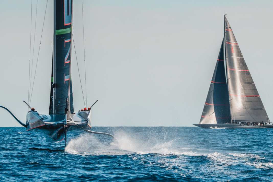 L'AC75 "Britannia" solca il campo di regata dell'America's Cup a Barcellona. Il J "Svea" svedese si intravede all'orizzonte