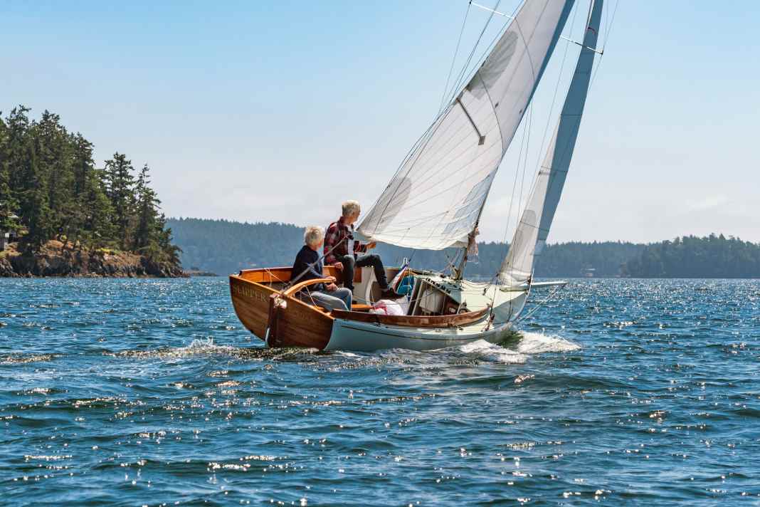 The small boat is characterised by a positive natural wood stern, the clear lacquered coaming and strong lines