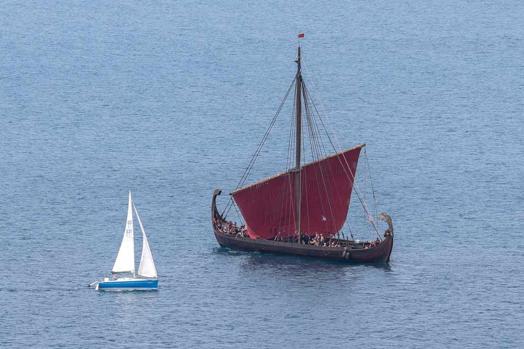 Da werden die Größenverhältnisse klar: Eine Segelyacht passiert während der Odysee-Dreharbeiten eines der Wikingerschiffe, die die antike Flotte des Homer-Epos verkörpern. | Louisa Gouliamaki