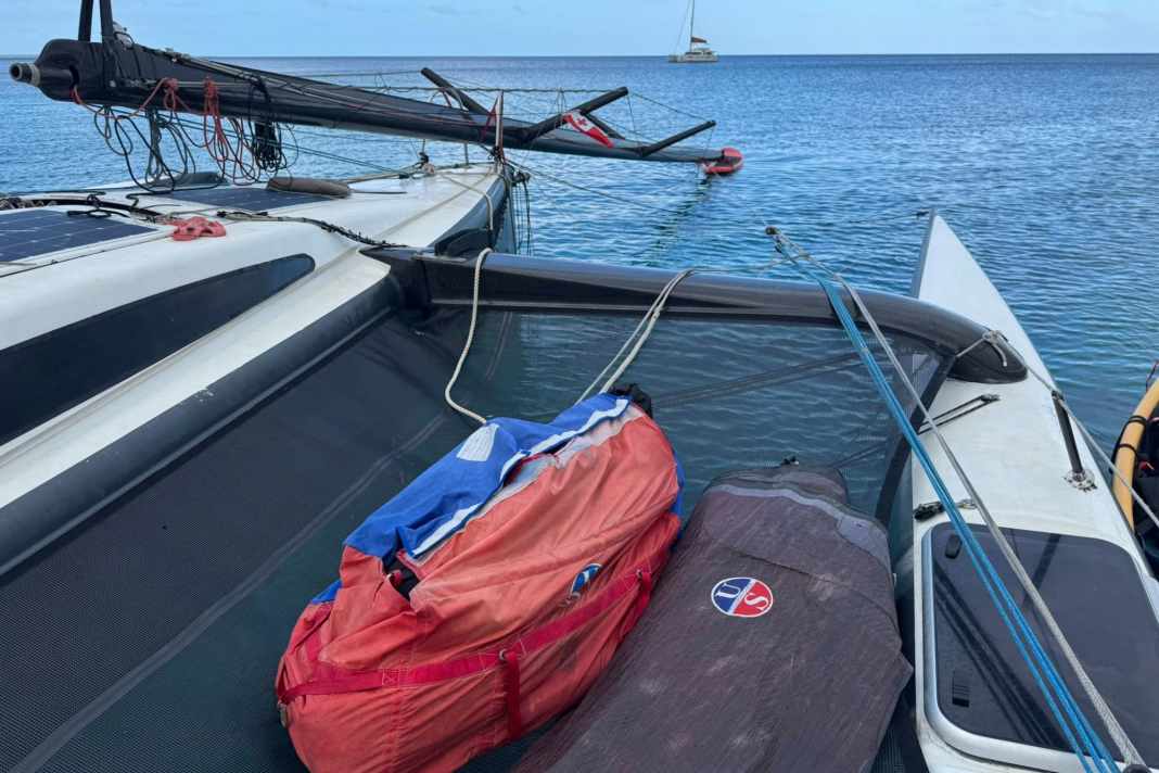 The mast of the "Black Marlin" towers above the deck and lies on a SUP in the water