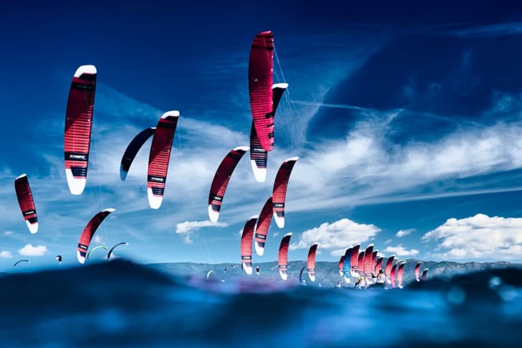 Das Bild zum Kitesport, der Himmel und Wasser miteinander verbindet.