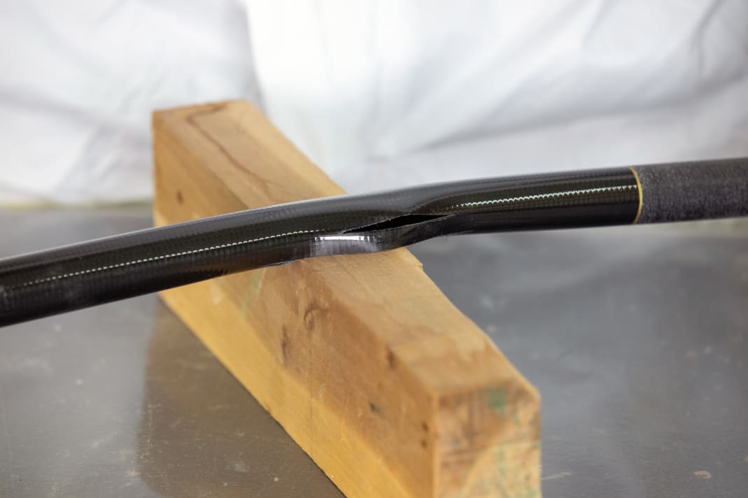 I bracci del timone in fibra di carbonio cedono rapidamente sotto il carico di instabilità, simulando il danno su una canna da pesca.