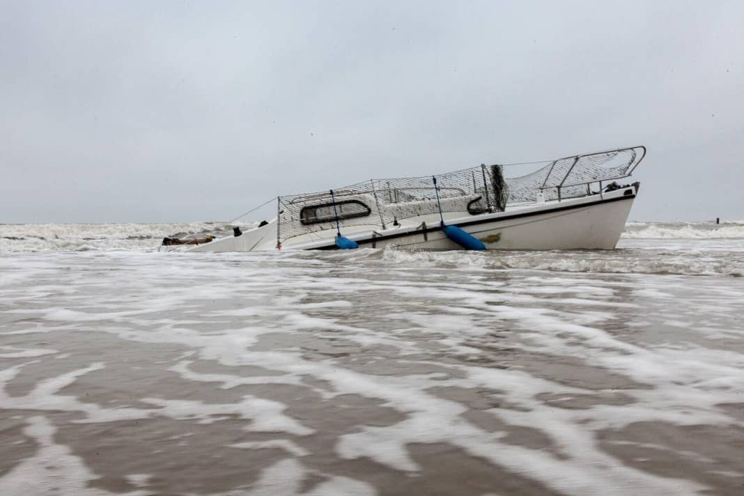 Als Totalschaden liegt das 6,50 Meter lange Boot halb über, halb unter Wasser und Sand am Strand