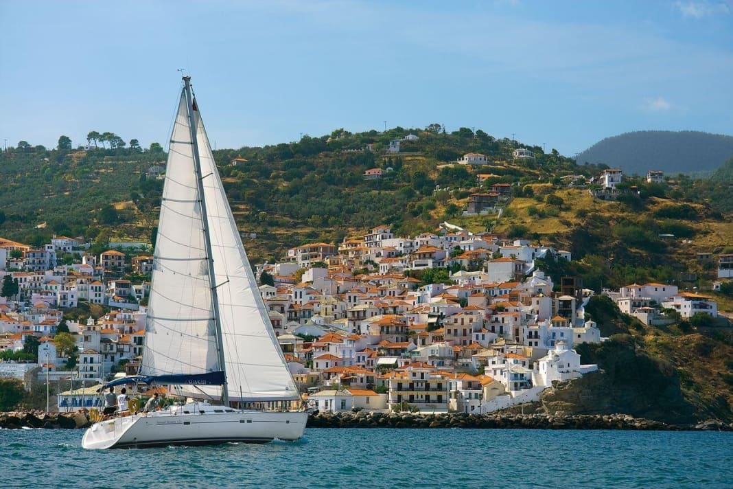 Yacht vor der Stadtkulisse von Skopelos auf der gleichnamigen Insel. Sie schmiegt sich malerisch an einen Berg