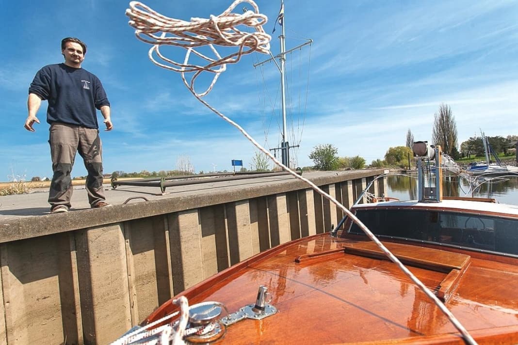 Un secondo uomo prende il comando della barca prima che questa scivoli in acqua alla fine dello scivolo...
