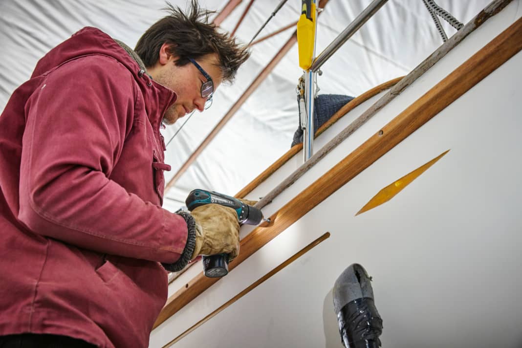 Damit die Holzleiste schon mal grobe Rempler verkraftet, wird sie angeklebt und verschraubt, dadurch lässt sie sich auch leichter montieren