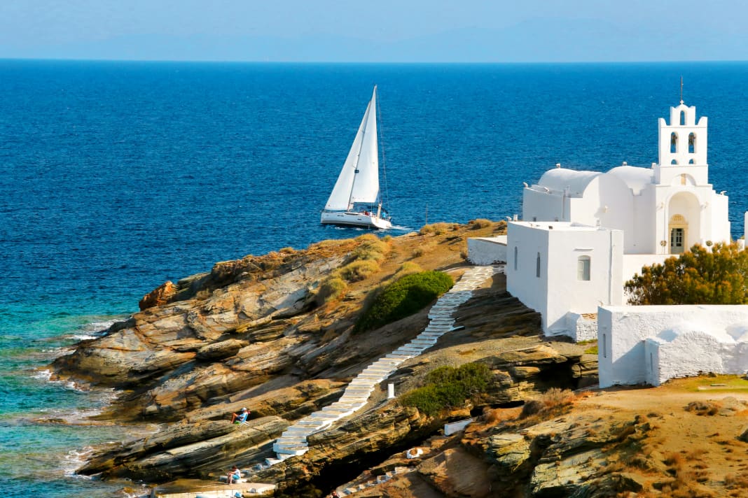 Uno yacht naviga davanti a una cappella sulla costa meridionale dell'isola di Sifnos. Solo questa isola offre baie e luoghi sufficienti per tre giorni.