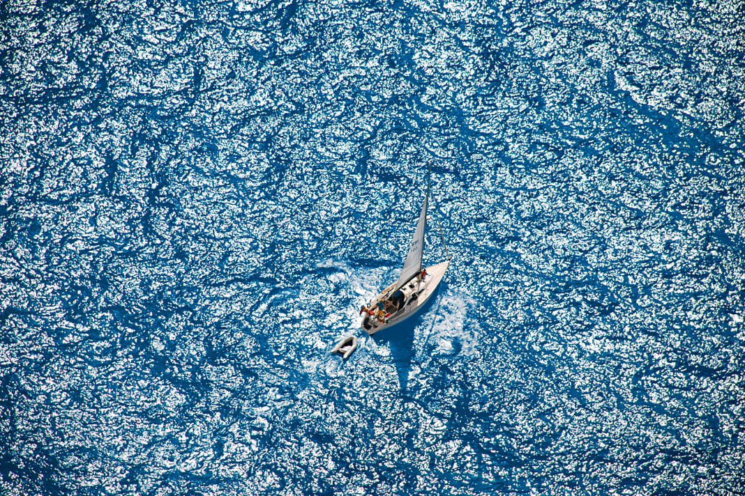 Alone in the ocean, a yacht travelling on blue water
