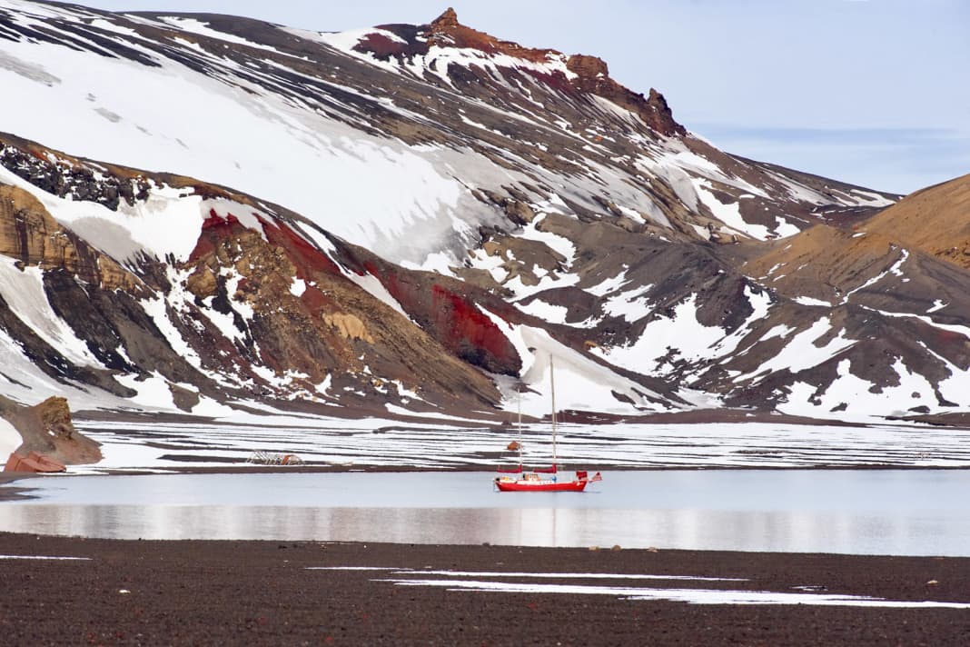 Le yacht en acier rouge vif de Kirchberger dans une baie déserte