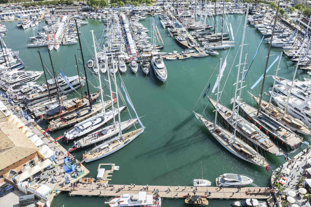 La vista aerea rivela le dimensioni impressionanti del Salone Nautico Internazionale di Palma, dove centinaia di yacht a vela e a motore affollano le acque blu intenso del porto turistico.