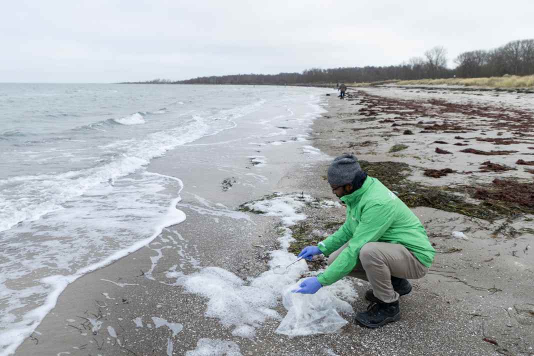 In Kühlungsborn entnimmt Dr. Julios Kontchou, Greenpeace, dem    Meeresschaum eine Probe, um ihn auf PFAS zu untersuchen.