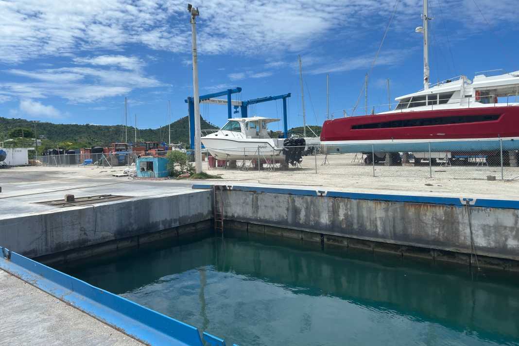 Vista sullo scalo di alaggio della Tyrell Bay Marina a Carriacou: la gru blu è pronta all’uso sullo sfondo, ma la via per tornare in acqua rimane bloccata.