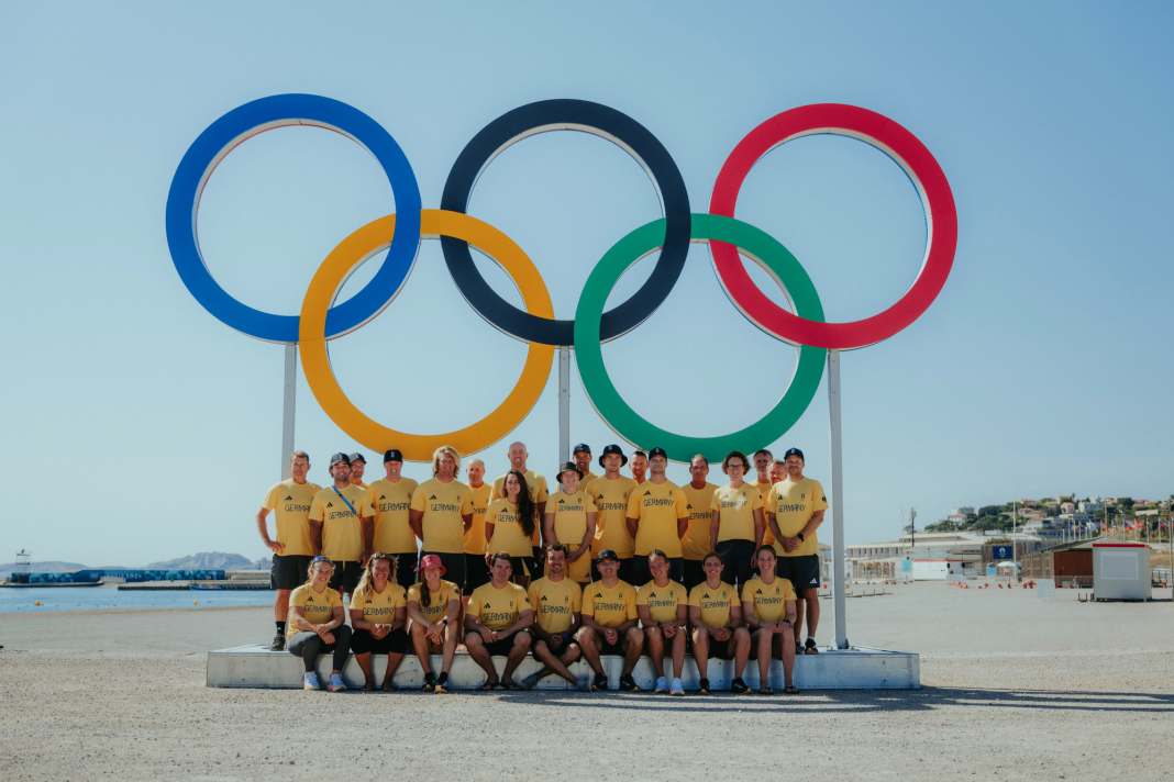 Die Segelnationalmannschaft und ihre Betreuer bei den fünf olympischen XL-Ringen am Strand von Marseille