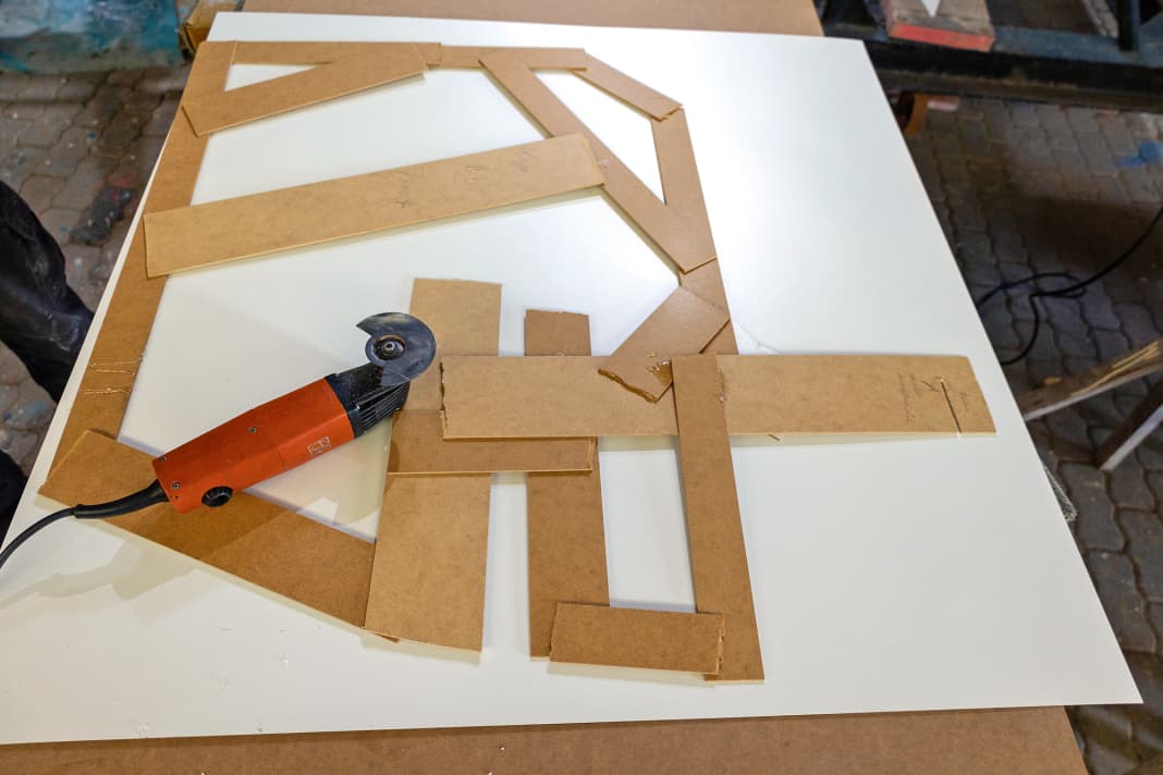 Laying: Thin Resopal is not usually available in DIY stores, but only in specialised joinery shops. There it usually has to be purchased as a whole sheet and is delivered as a large roll. To coat the individual bulkheads, the material is first roughly cut into more manageable pieces