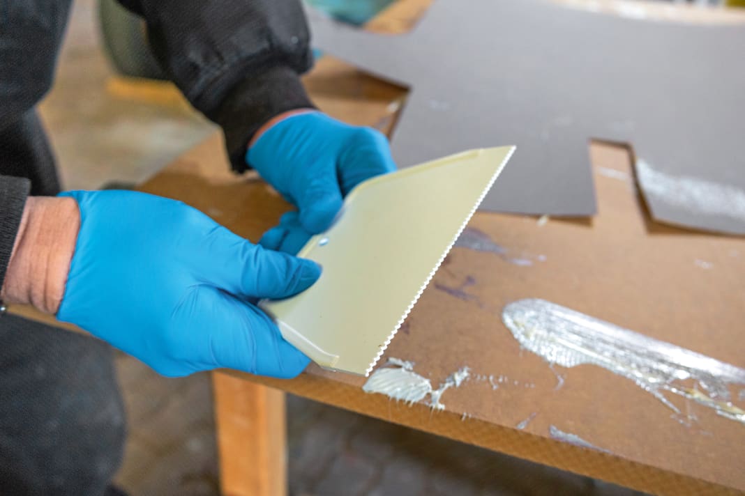 Denti fini: per applicare l'adesivo in modo uniforme, è necessario utilizzare una spatola dentata con denti fini. Se l'utensile è troppo grosso, come nel caso della posa delle piastrelle, lo strato di adesivo sarà troppo spesso e non potrà essere pressato in modo uniforme. Il rivestimento diventa ondulato. Nel peggiore dei casi, il materiale si rompe se si cerca di forzarlo in modo uniforme. L'adesivo in dispersione AF 270 di Ardex che utilizziamo viene fornito pronto all'uso dal secchio. Tuttavia, è possibile utilizzare anche altri adesivi disponibili sul mercato per i rivestimenti interni.