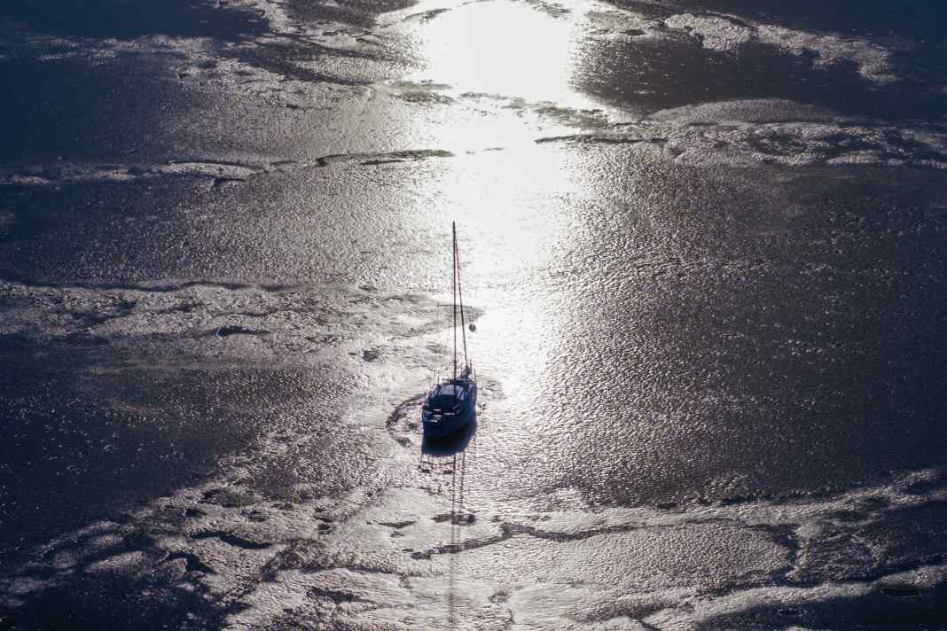 Una barca a vela giace nel ghiaccio al largo del porto di Kirchdorf, tra l'isola di Poel e il Mar Baltico.