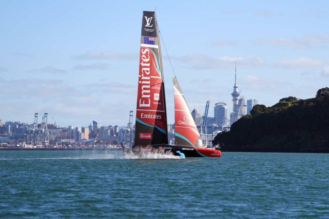 Rückkehr auf heimische Gewässer: Der AC75-Foiler „Taihoro" auf dem Golf von Hauraki vor der Skyline Aucklands.