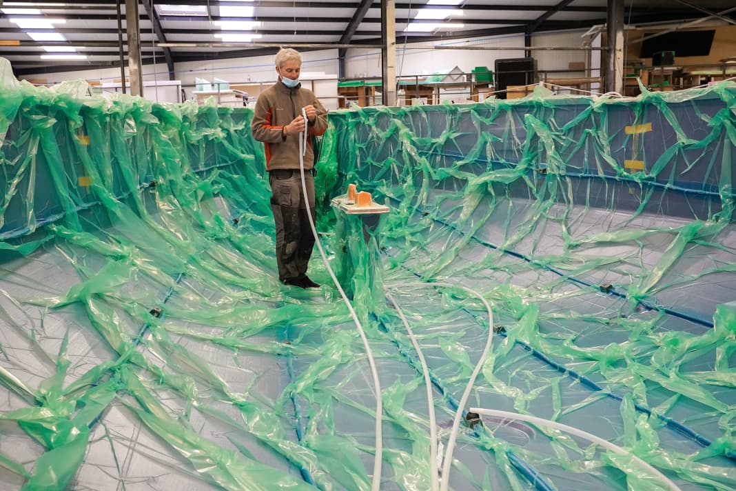 In the vacuum infusion process, dry glass fibres and foam sheets are placed in the mould as the core material and sealed with a film. The resin is then sucked into the laminate structure under vacuum and the structures are cured