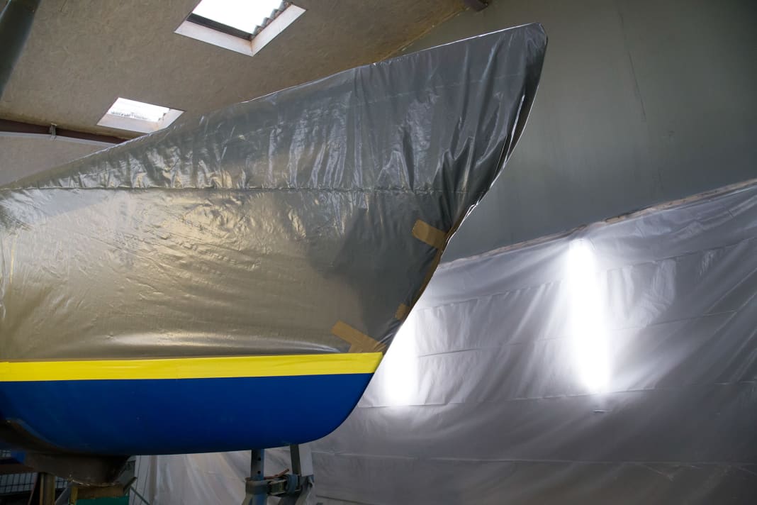 Before blasting, the surface vessel is packed dust-tight, and robust adhesive tape protects the gelcoat at the water pass