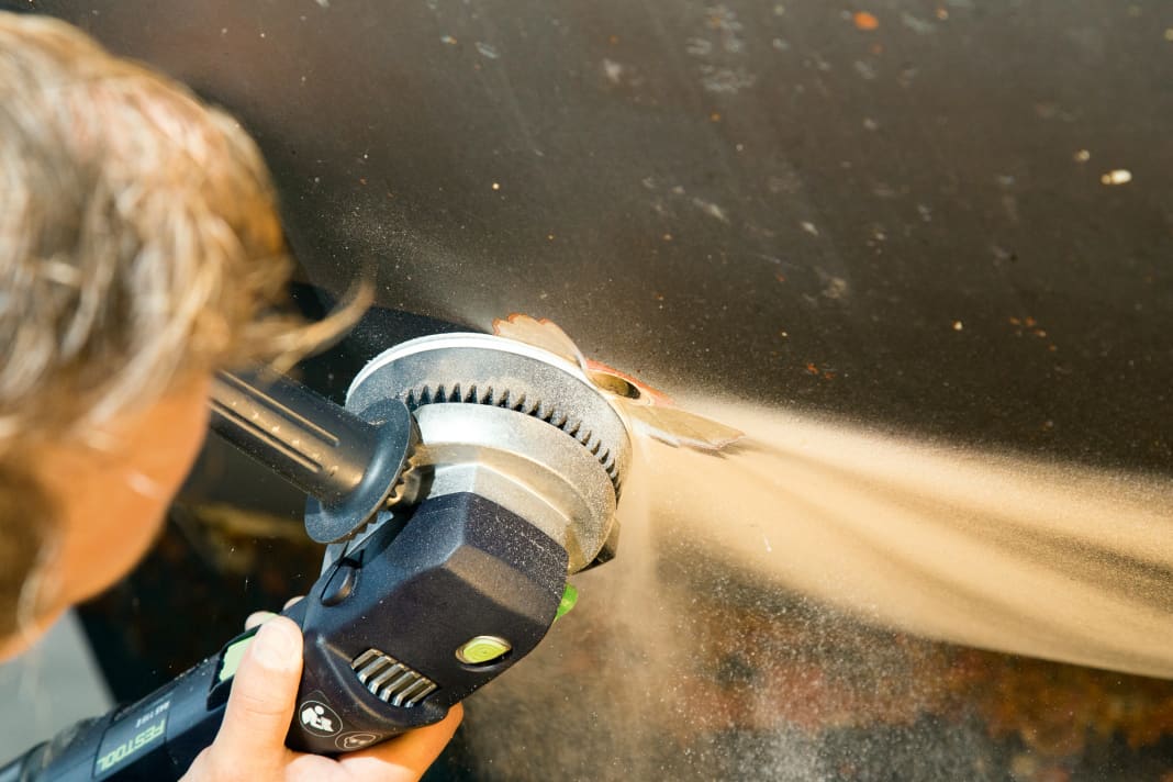 Bei alten Borddurchlässen sind die Verschraubungen meist festgegammelt, daher schleift man den außen überstehenden Teil einfach mit der Flex ab. Abrutschen ist kein Problem, das Loch muss sowieso noch weiter aufgeschliffen werden