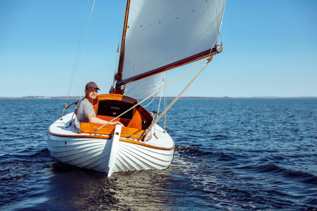 Satisfied all round. Florian Melzer at the tiller of his restored pointed gaff from 1946