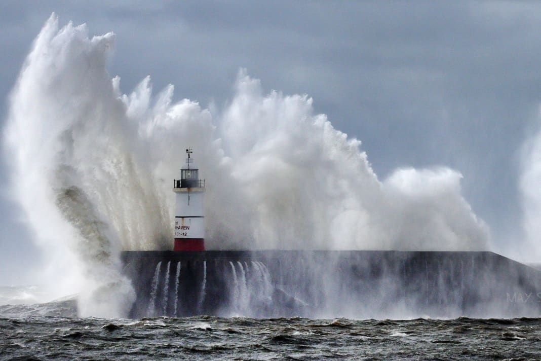 Les vagues s'écrasent contre le mur du port du phare de Newhaven à Newhaven, Grande-Bretagne