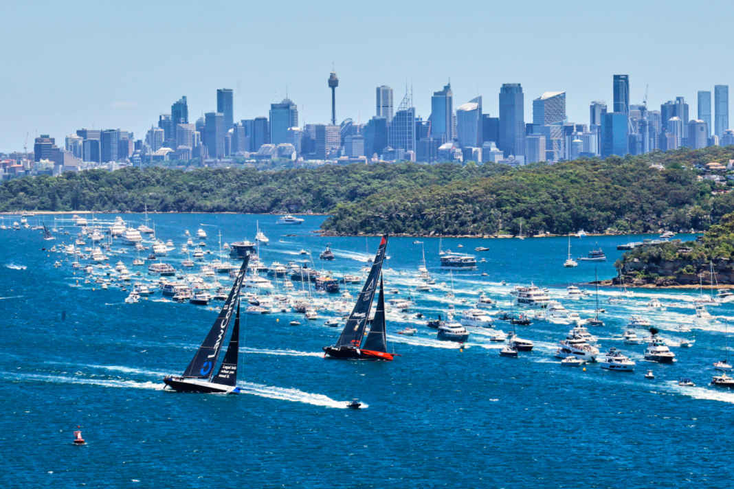 The 100-foot maxis "Master Lock Comanche" and "LawConnect" are flanked by an armada of spectators.