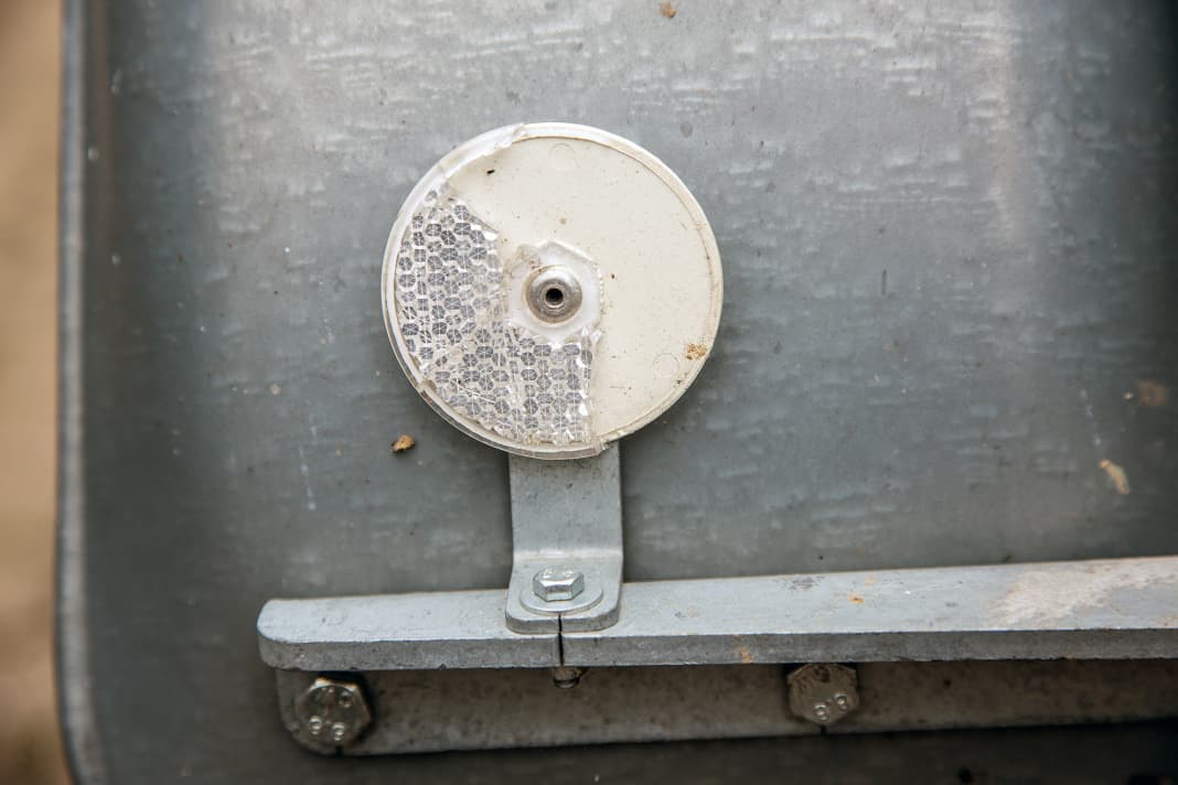 Dommages typiques dus à des gravillons sur le réflecteur du passage de roue. Une pièce de rechange qui coûte à peine plus d'un euro, mais qui peut coûter la plaquette lors du contrôle technique.